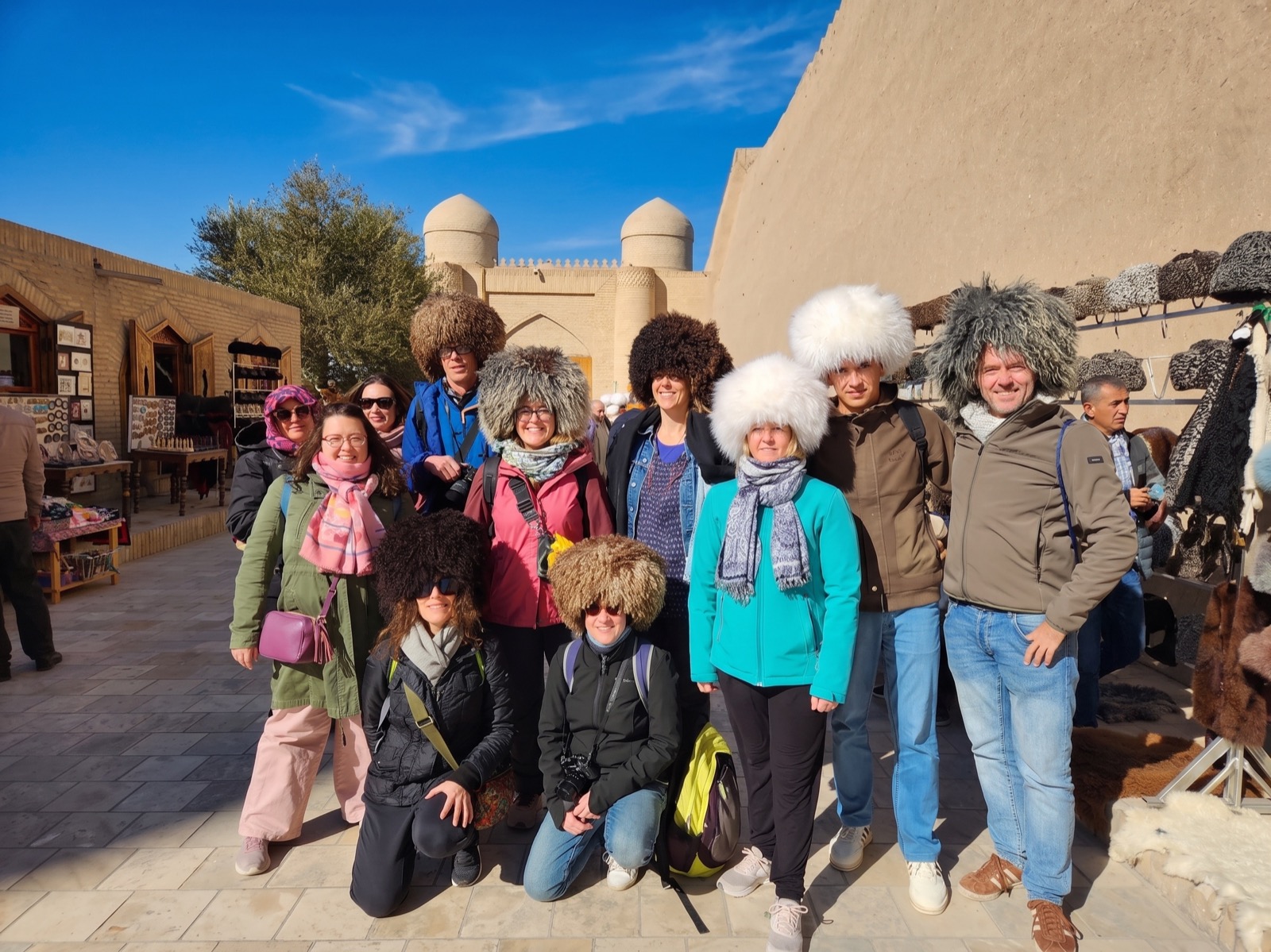 Gruppo Meeters con i tradizionali cappelli telpak davanti alle mura di Khiva